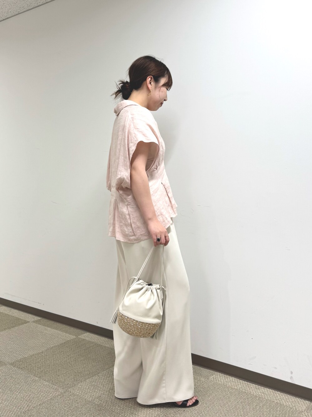 ピンク系のシャツ/ブラウス、ベージュ系のその他パンツ、ホワイト系のショルダーバッグを着用したレディースの春コーディネートの2枚目の写真