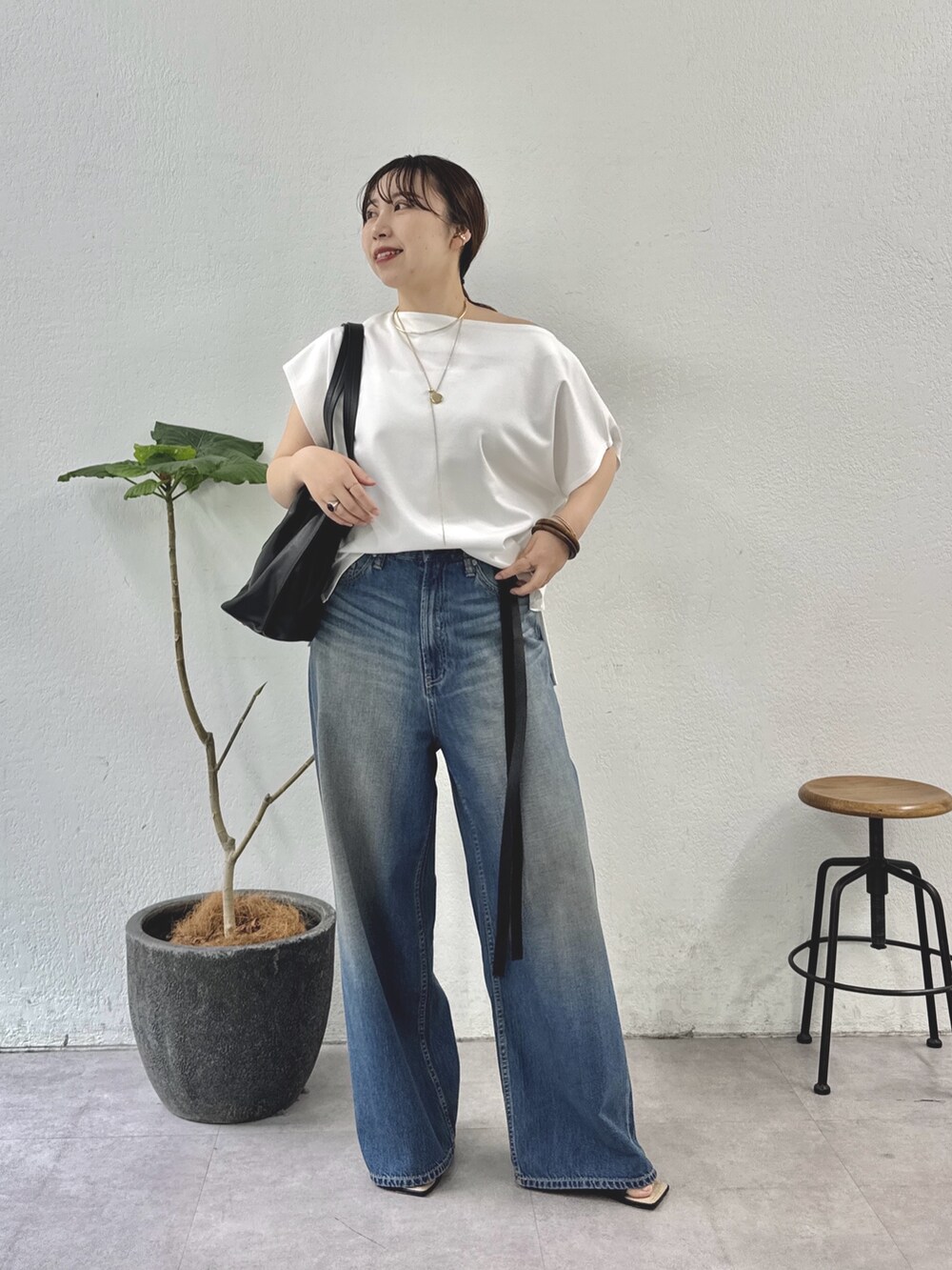 ホワイト系のTシャツ/カットソー、ブルー系のデニムパンツ、ブラック系のトートバッグを着用したレディースの夏コーディネートの3枚目の写真