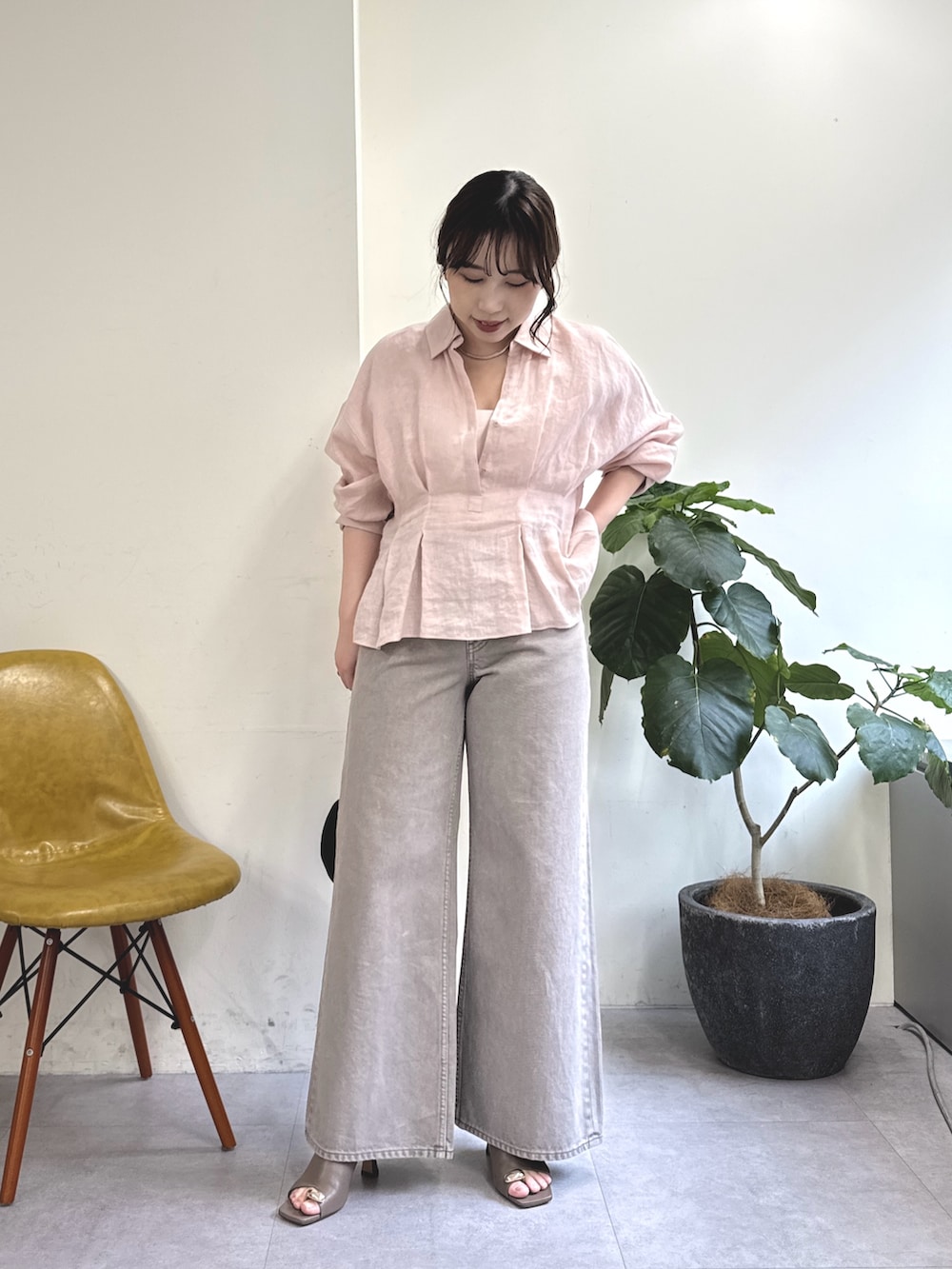 ブラウン系のデニムパンツ、ブラック系のトートバッグ、ブラウン系のサンダルを着用したレディースの春コーディネートの3枚目の写真