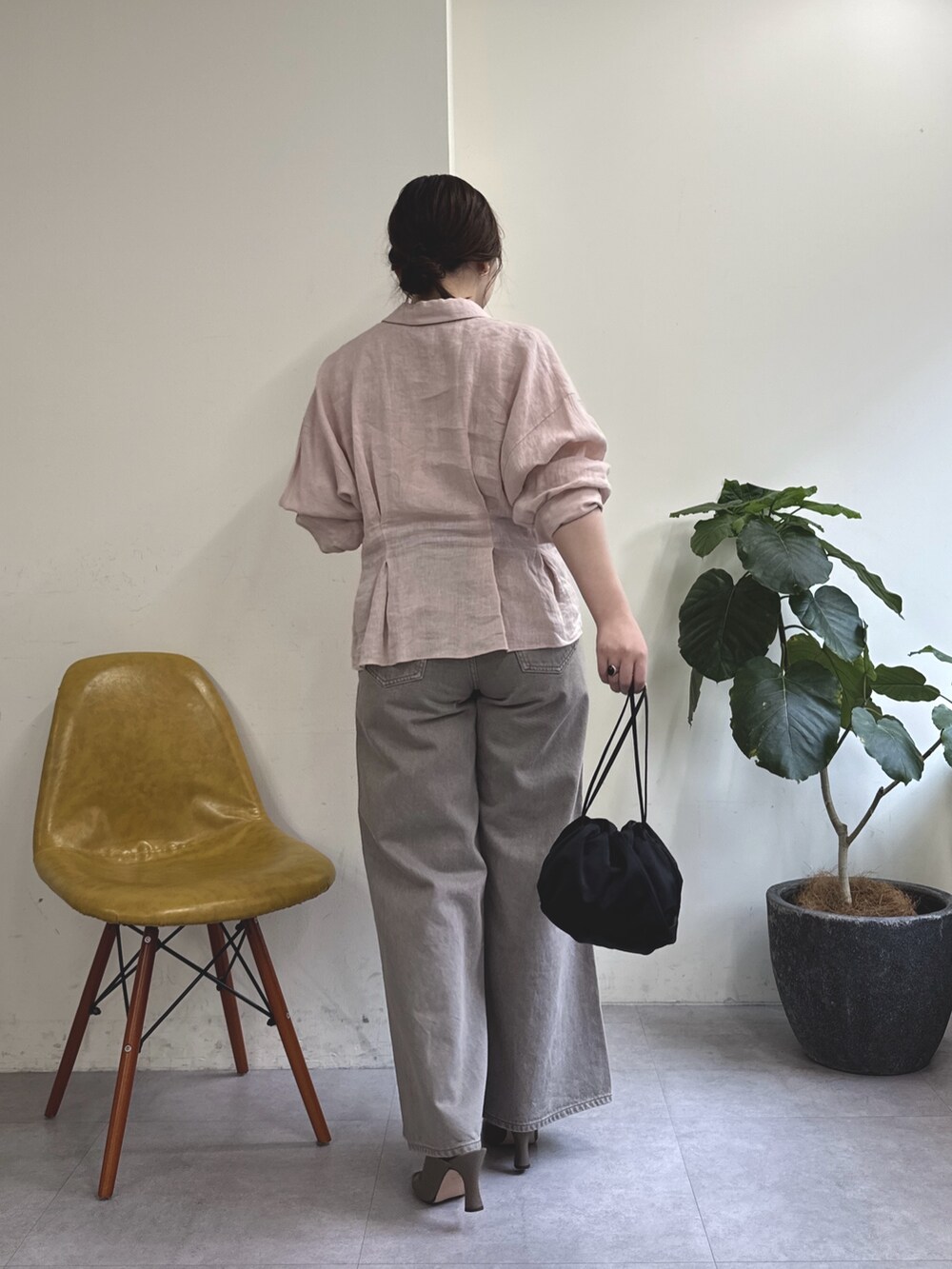 ブラウン系のデニムパンツ、ブラック系のトートバッグ、ブラウン系のサンダルを着用したレディースの春コーディネートの5枚目の写真