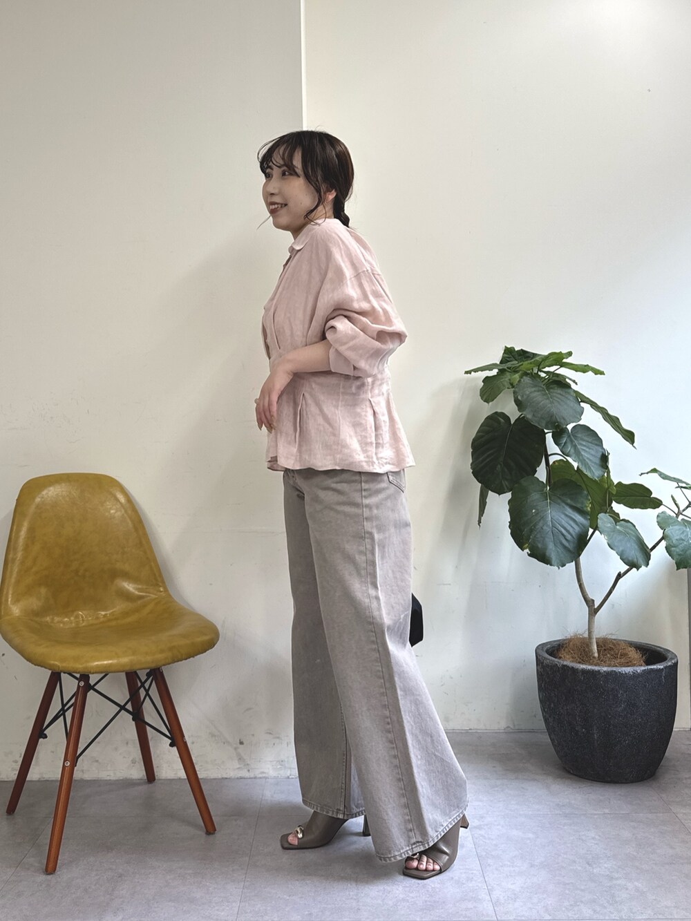 ブラウン系のデニムパンツ、ブラック系のトートバッグ、ブラウン系のサンダルを着用したレディースの春コーディネートの4枚目の写真