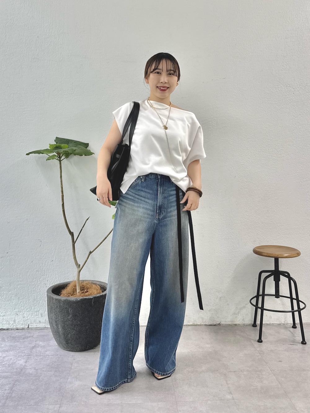 ホワイト系のTシャツ/カットソー、ブルー系のデニムパンツ、ブラック系のトートバッグを着用したレディースの夏コーディネートの2枚目の写真