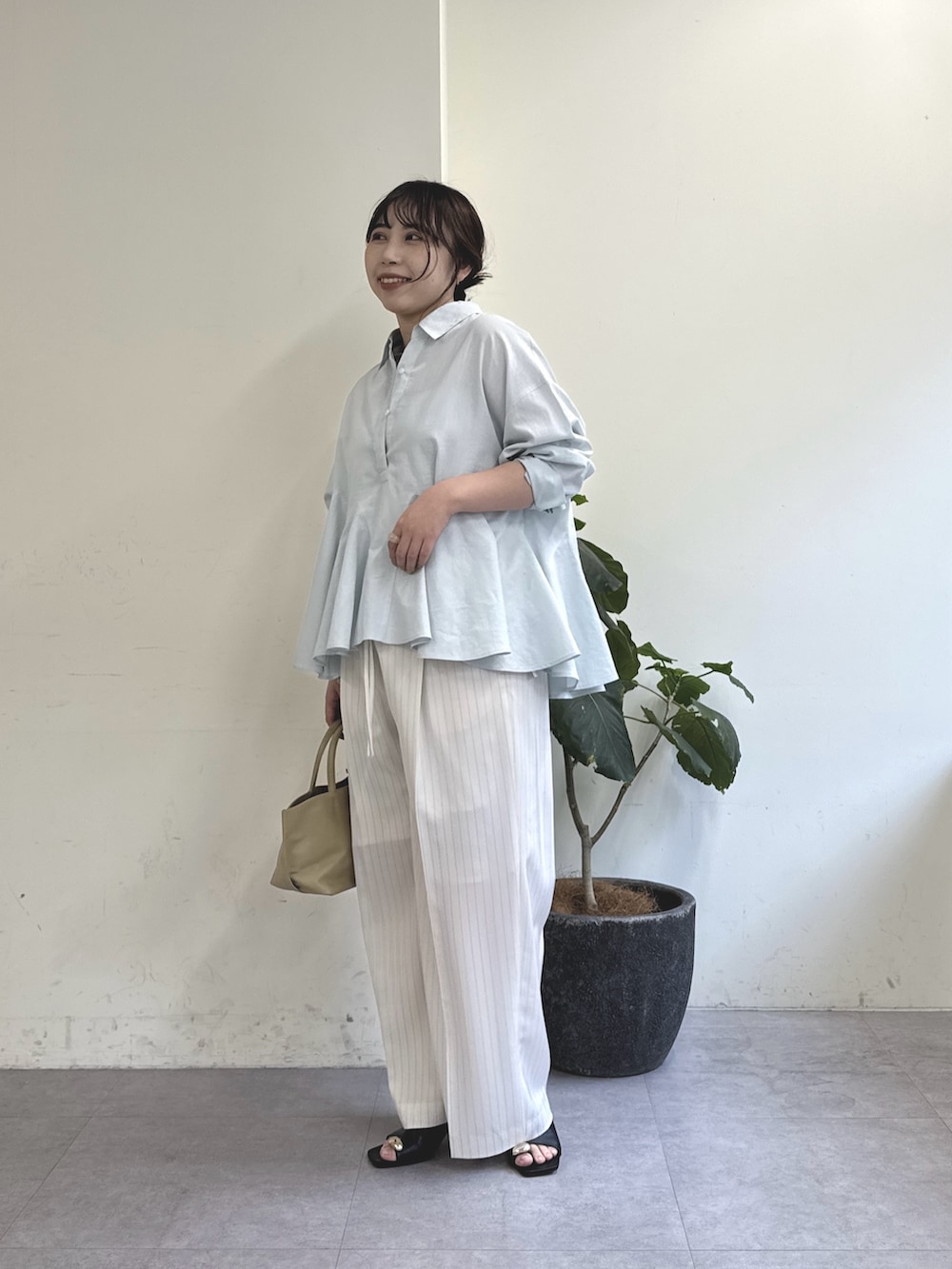 ホワイト系のその他パンツ、ブラック系のサンダル、ベージュ系のトートバッグを着用したレディースの冬コーディネートの2枚目の写真