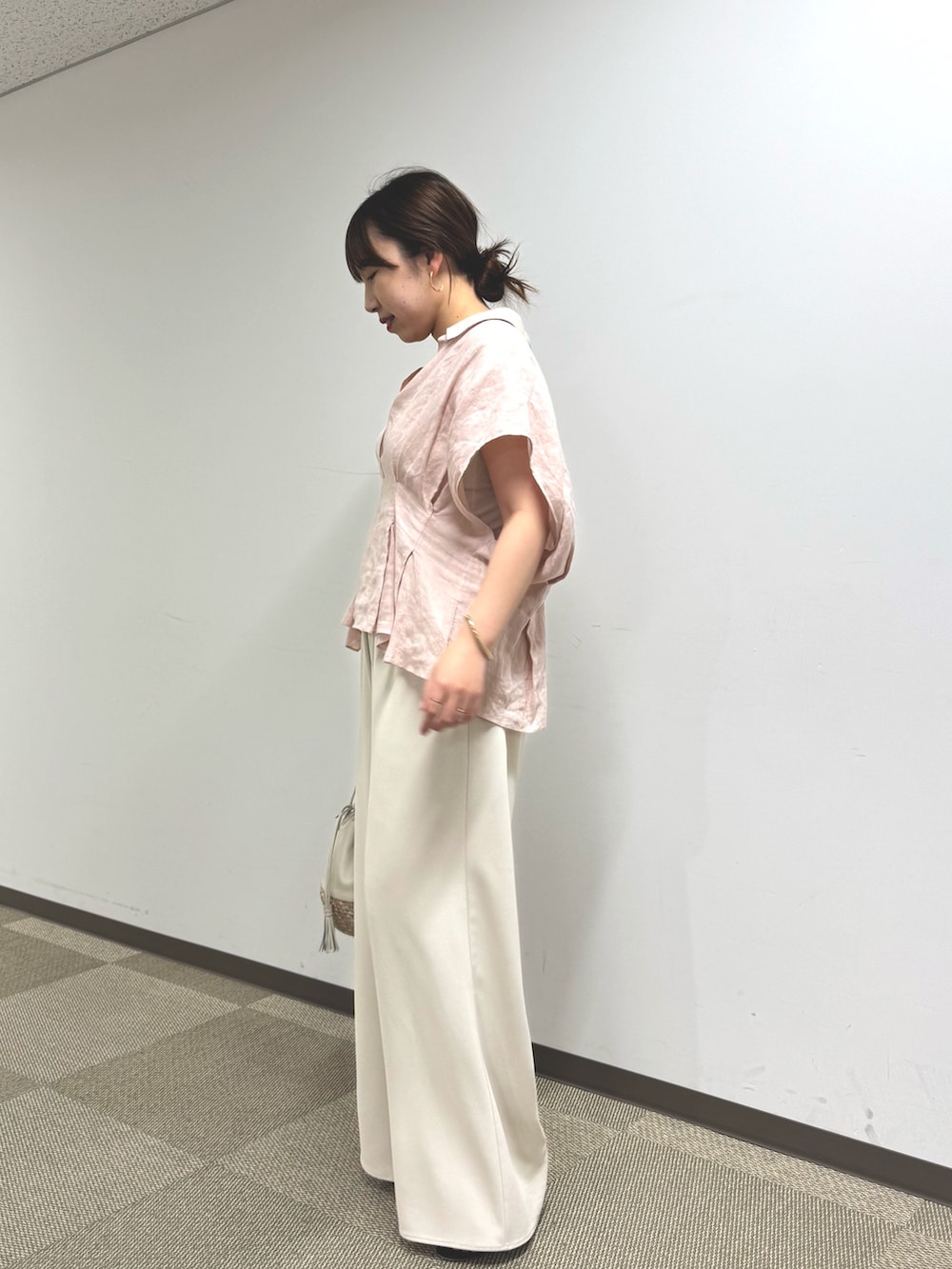 ピンク系のシャツ/ブラウス、ベージュ系のその他パンツ、ホワイト系のショルダーバッグを着用したレディースの春コーディネートの3枚目の写真