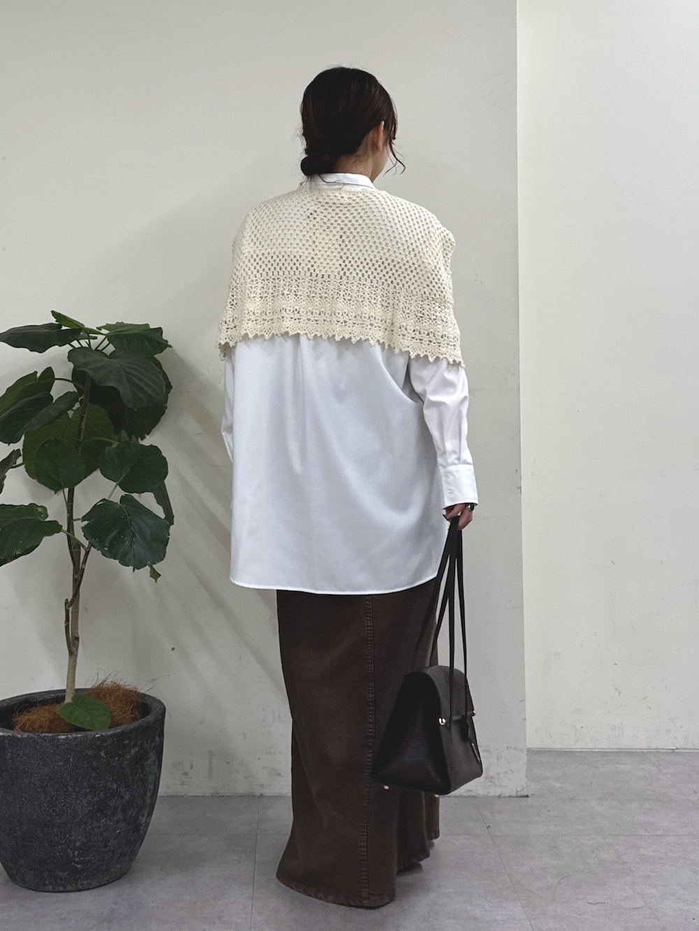 ブラウン系のスカート、ブラウン系のトートバッグ、ホワイト系のニット/セーターを着用したレディースの秋コーディネートの5枚目の写真