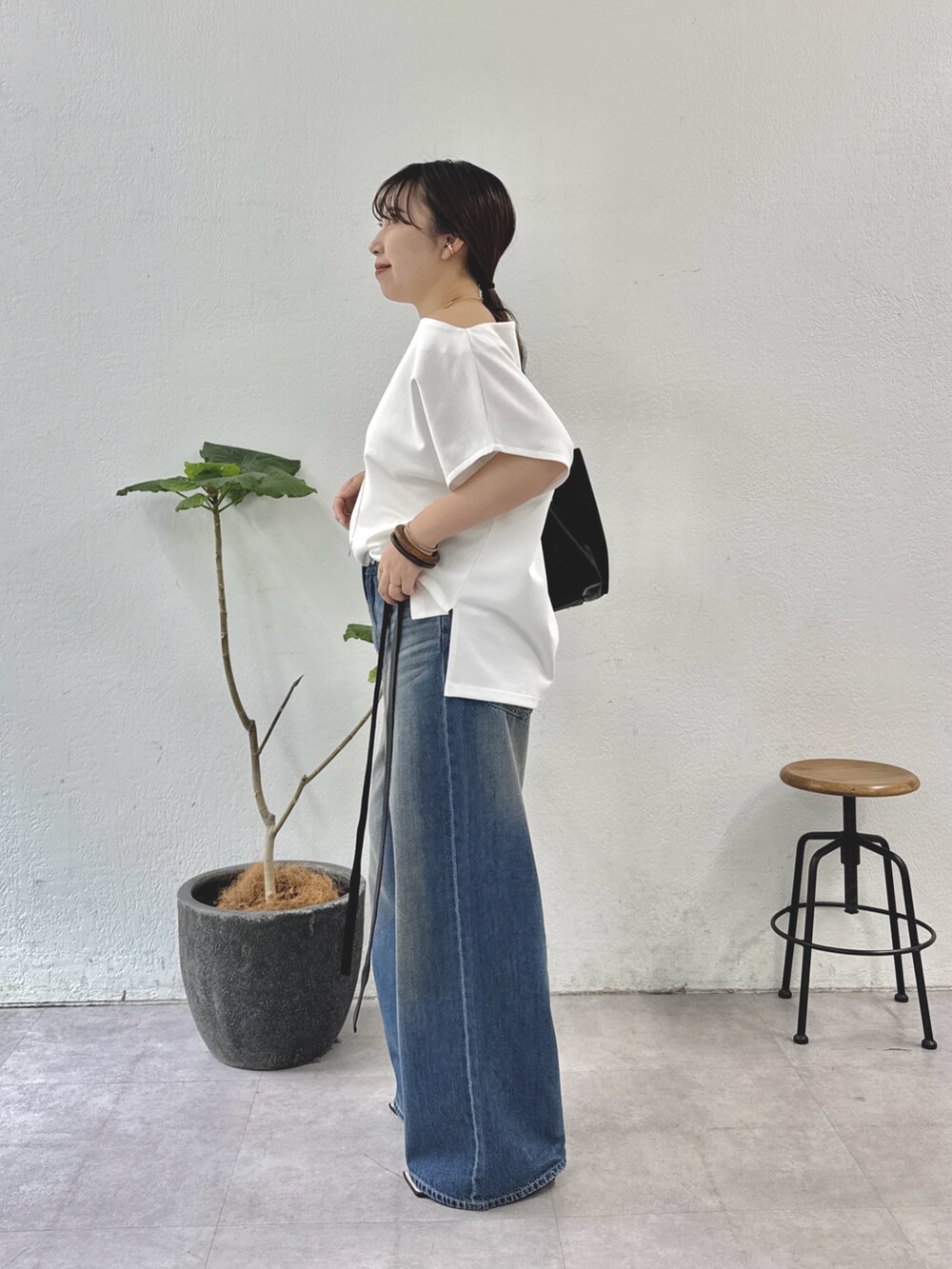 ホワイト系のTシャツ/カットソー、ブルー系のデニムパンツ、ブラック系のトートバッグを着用したレディースの夏コーディネートの4枚目の写真