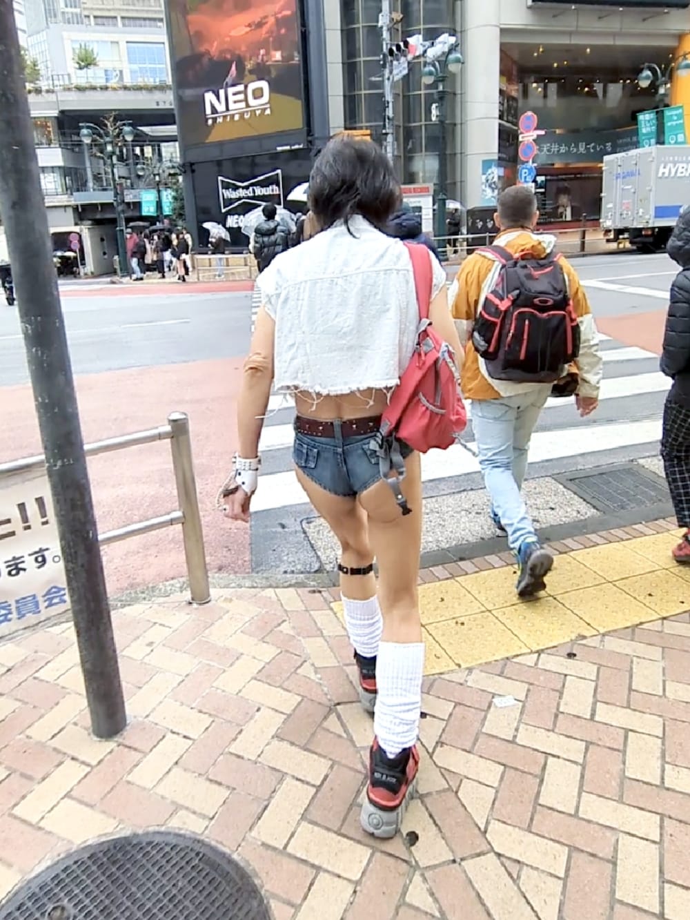 レッド系のスニーカー、ホワイト系のベスト、ブラック系のタンクトップを着用したメンズの冬コーディネートの2枚目の写真