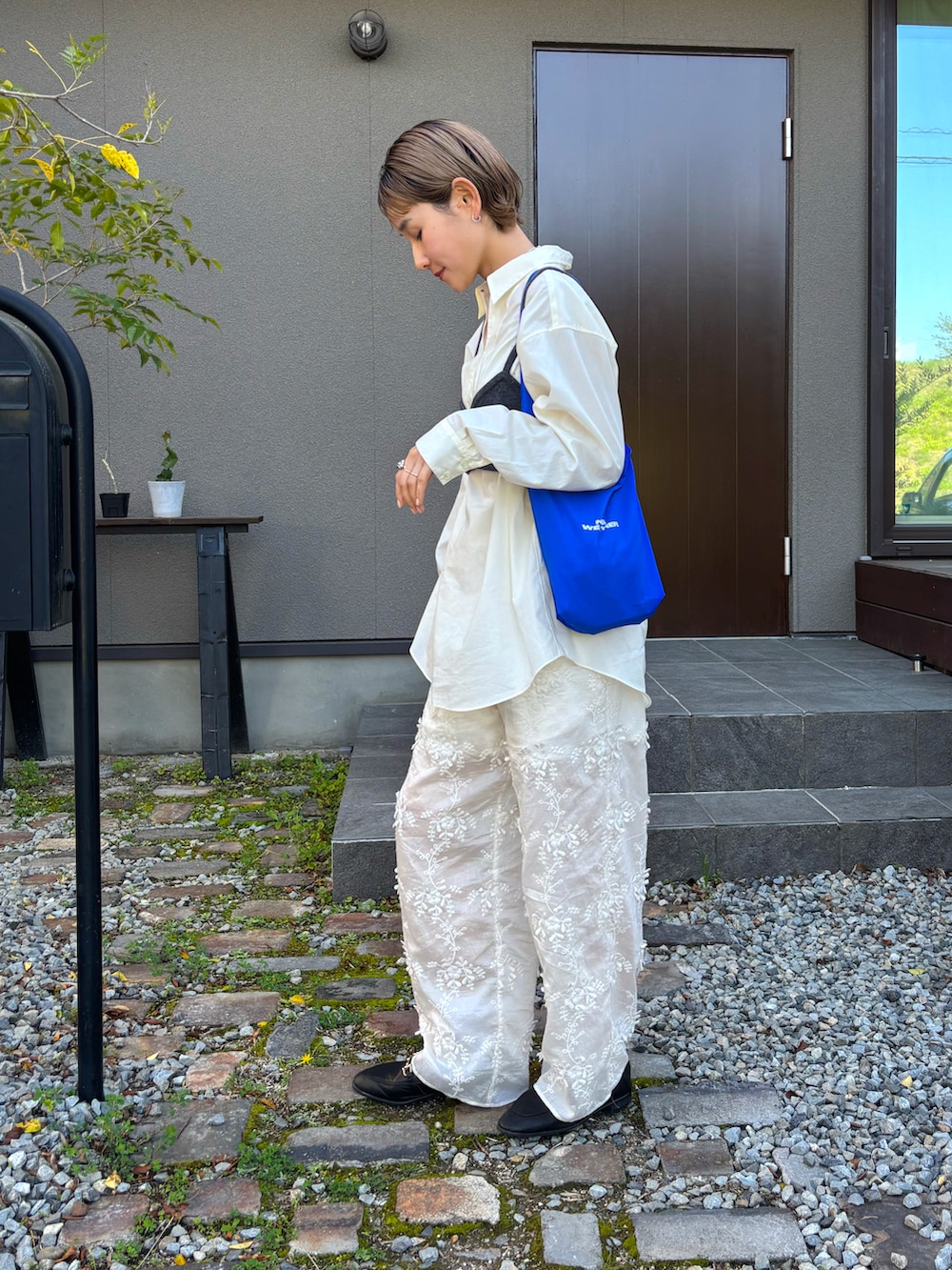 グレー系のその他トップス、ホワイト系のシャツ/ブラウス、ブルー系のショルダーバッグを着用したレディースの春コーディネートの2枚目の写真