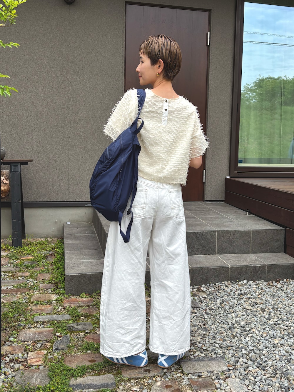 ホワイト系のTシャツ/カットソー、ホワイト系のデニムパンツ、ブルー系のスニーカーを着用したレディースの夏コーディネートの3枚目の写真
