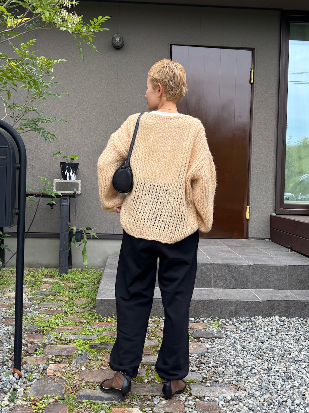 オレンジ系のニット/セーター、ブラック系のその他パンツ、ブラック系のサンダルを着用したレディースの秋コーディネートの3枚目の写真