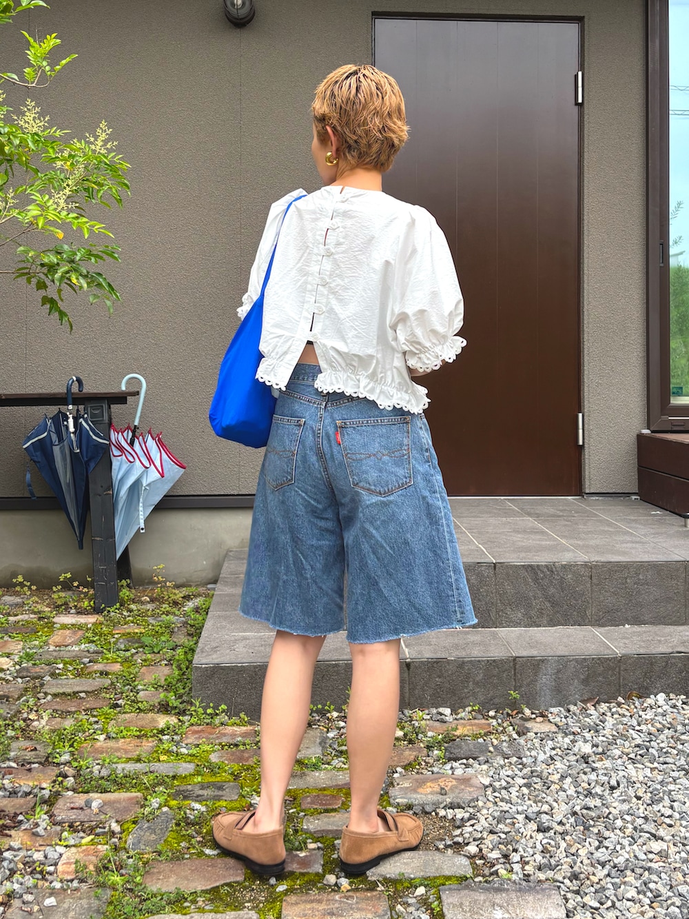 ホワイト系のシャツ/ブラウス、ブルー系のデニムパンツ、ブラウン系のローファーを着用したレディースの夏コーディネートの3枚目の写真