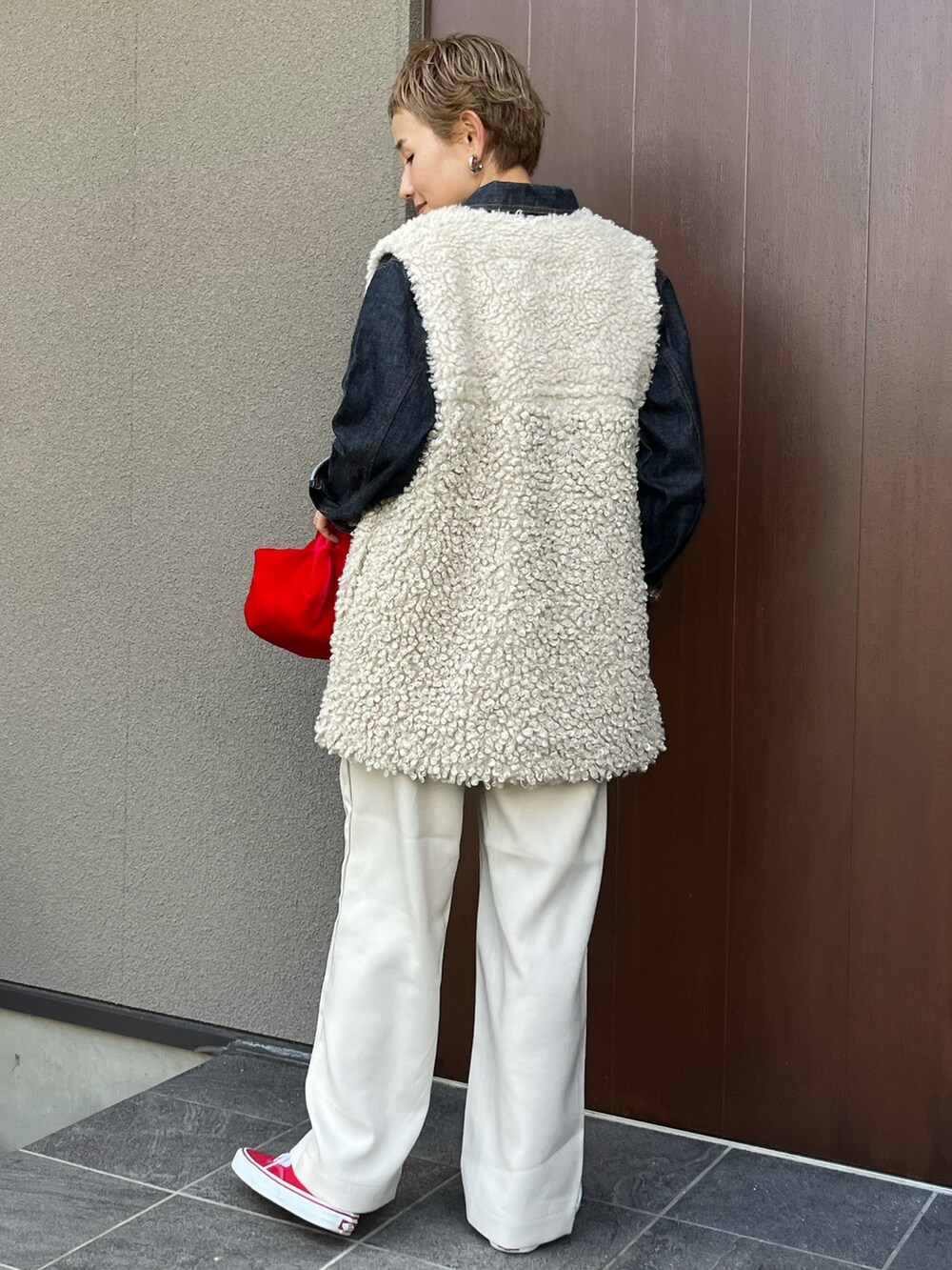 ベージュ系のベスト、ホワイト系のその他パンツ、レッド系のスニーカーを着用したレディースの秋コーディネートの3枚目の写真