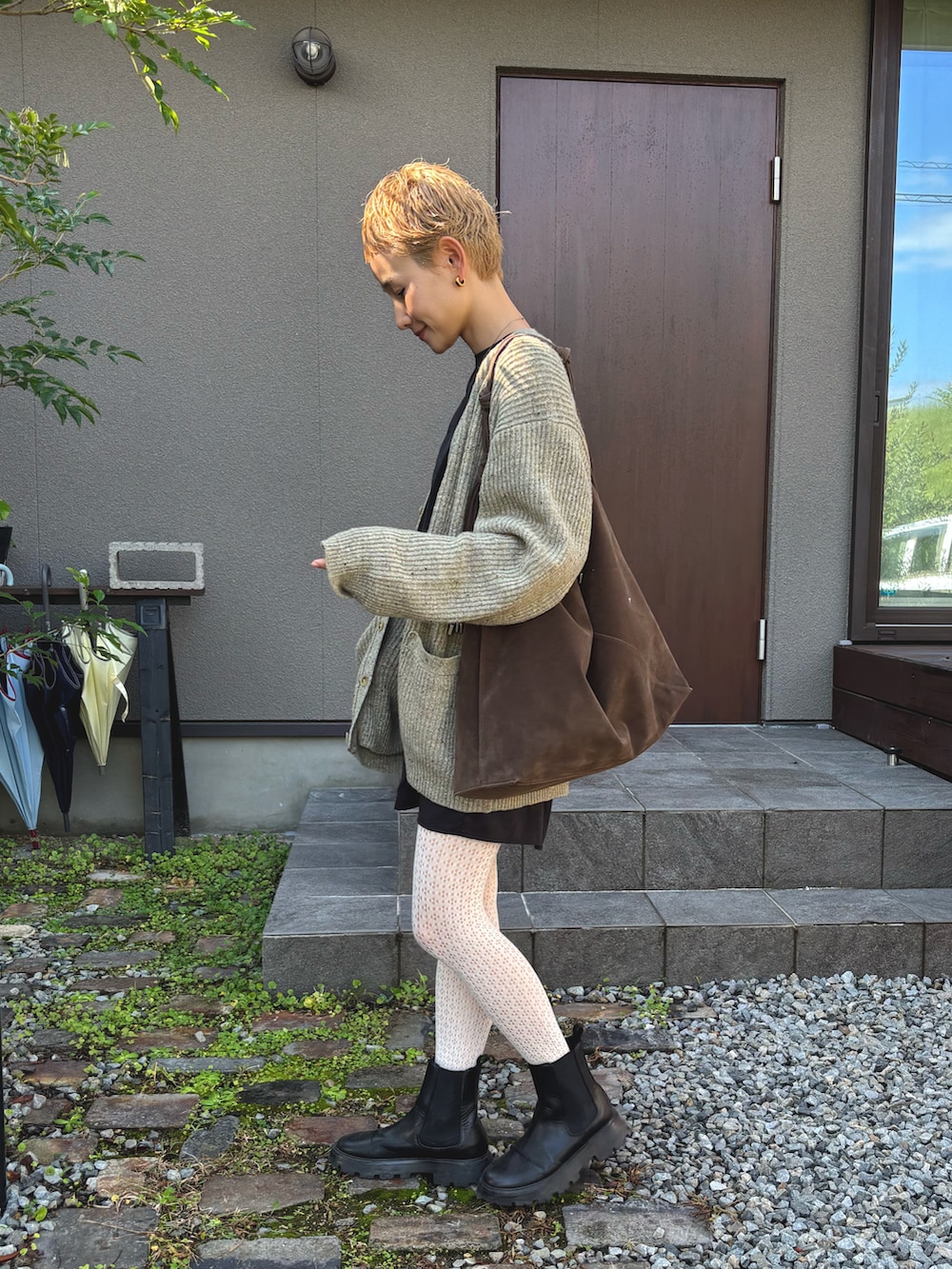 ブラック系のワンピース、グリーン系のショルダーバッグ、グリーン系のカーディガン/ボレロを着用したレディースの秋コーディネートの2枚目の写真