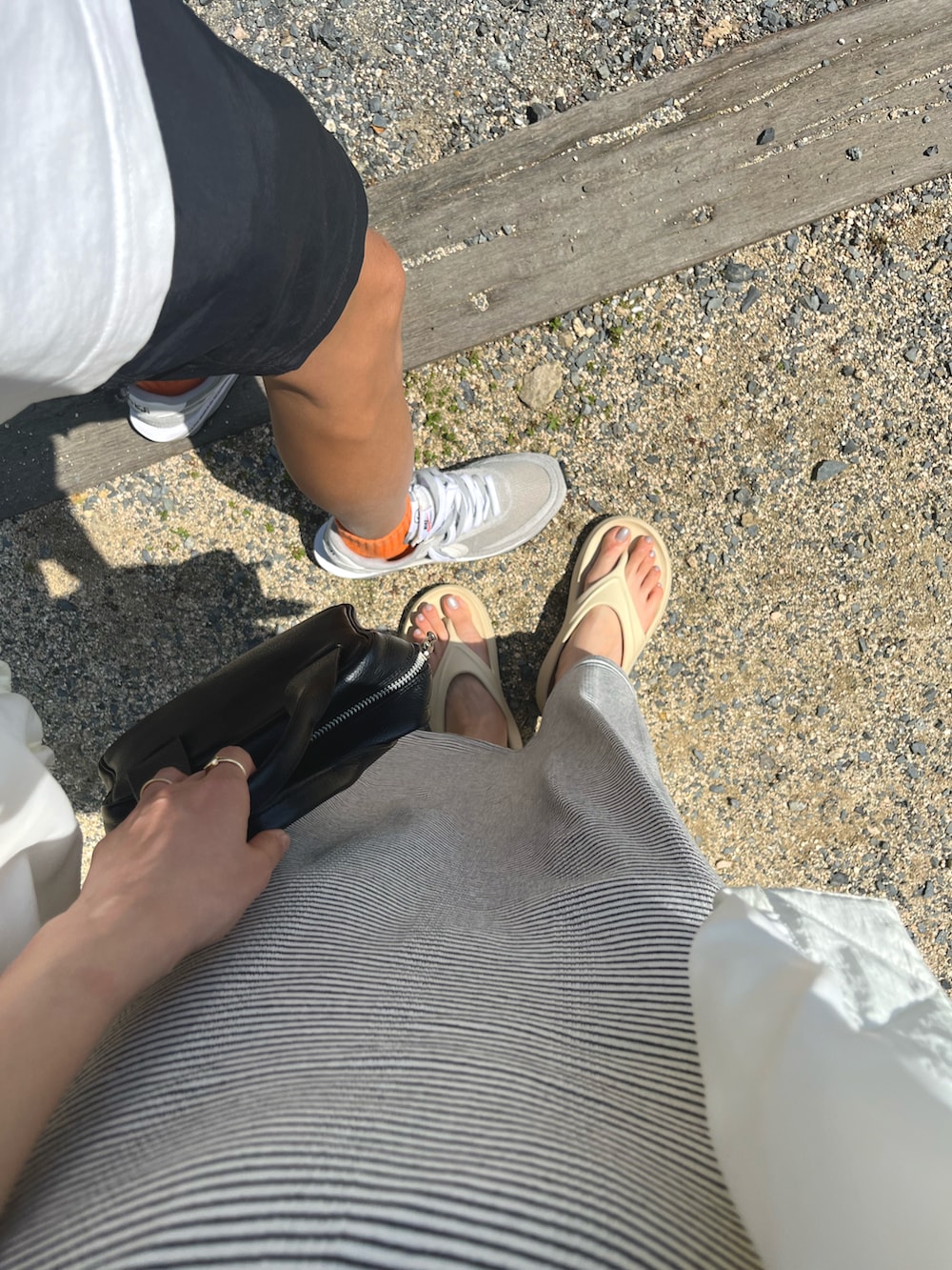 ブルー系のスカート、ブルー系のタンクトップ、ホワイト系のブルゾンを着用したレディースの春コーディネートの3枚目の写真