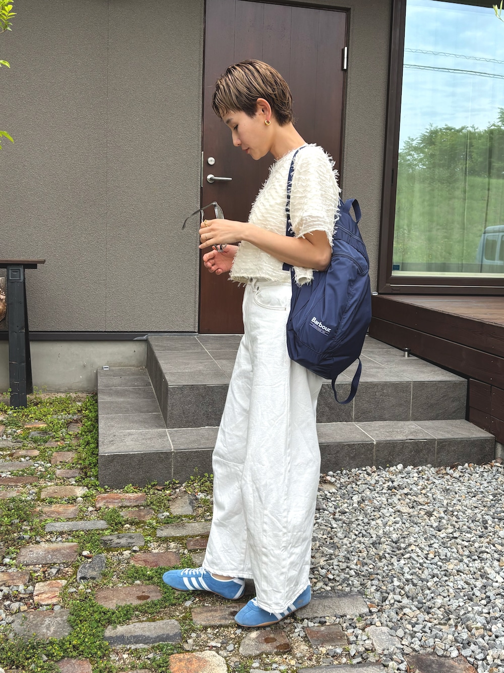 ホワイト系のTシャツ/カットソー、ホワイト系のデニムパンツ、ブルー系のスニーカーを着用したレディースの夏コーディネートの2枚目の写真