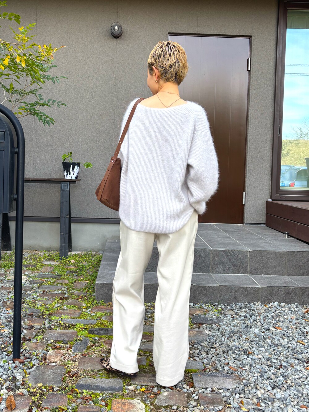 ブラウン系のショルダーバッグ、ホワイト系のニット/セーター、ホワイト系のその他パンツを着用したレディースの冬コーディネートの3枚目の写真