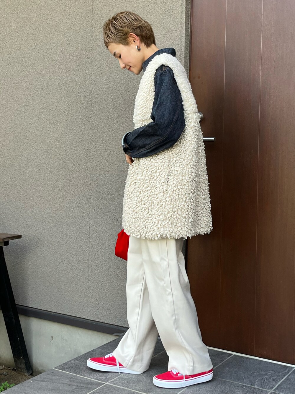 ベージュ系のベスト、ホワイト系のその他パンツ、レッド系のスニーカーを着用したレディースの秋コーディネートの2枚目の写真