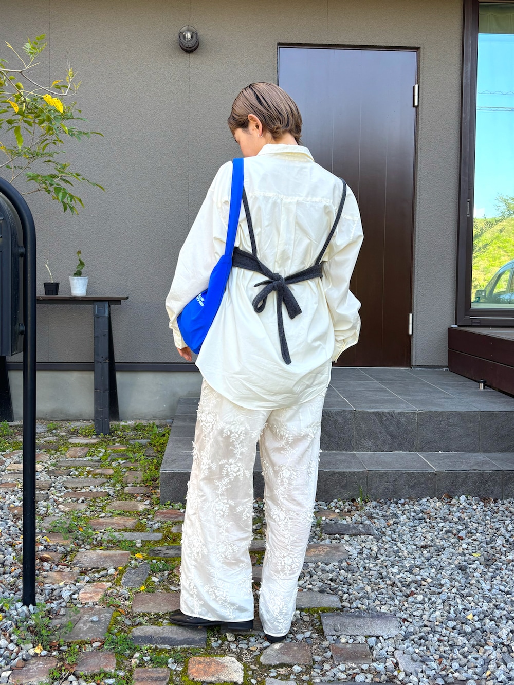 グレー系のその他トップス、ホワイト系のシャツ/ブラウス、ブルー系のショルダーバッグを着用したレディースの春コーディネートの3枚目の写真