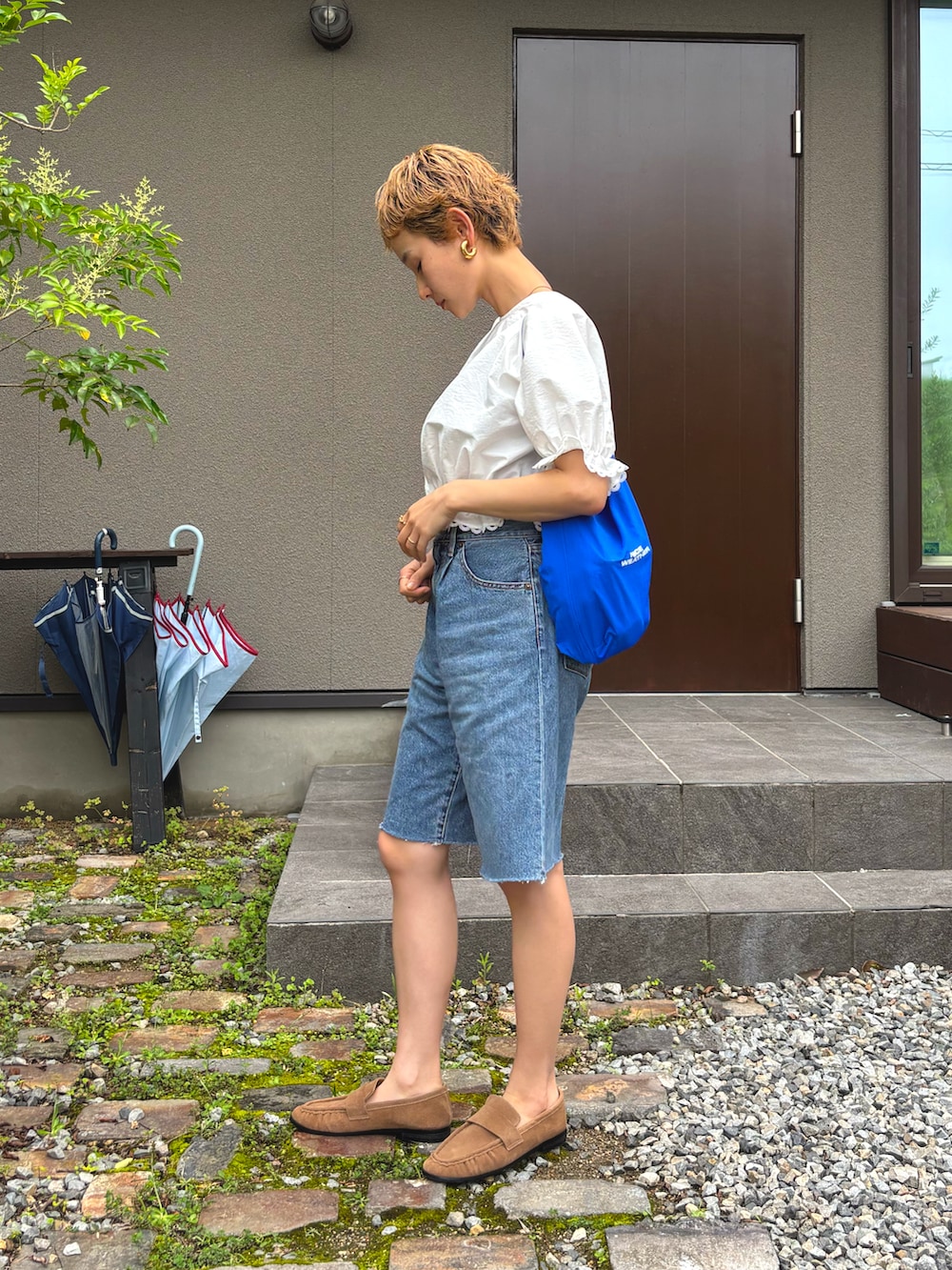 ホワイト系のシャツ/ブラウス、ブルー系のデニムパンツ、ブラウン系のローファーを着用したレディースの夏コーディネートの2枚目の写真