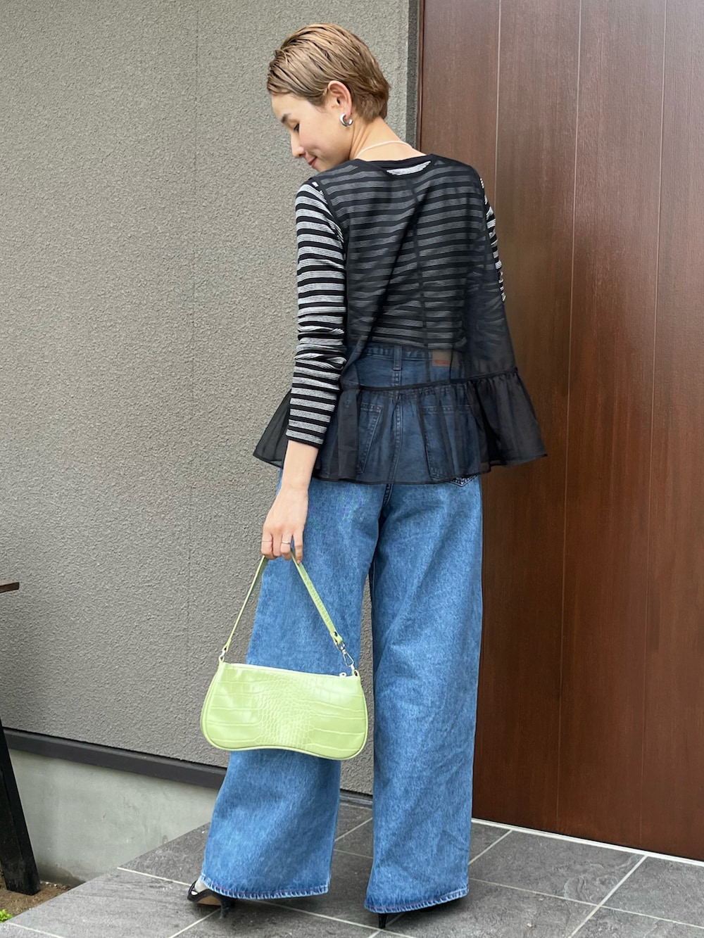ブラック系のベスト、ブラック系のTシャツ/カットソー、ブルー系のデニムパンツを着用したレディースの春コーディネートの3枚目の写真