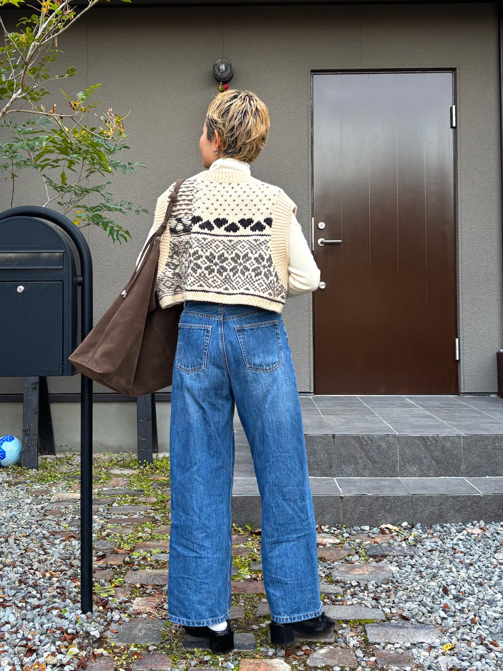 ホワイト系のニット/セーター、ベージュ系のベスト、グリーン系のショルダーバッグを着用したレディースの冬コーディネートの3枚目の写真