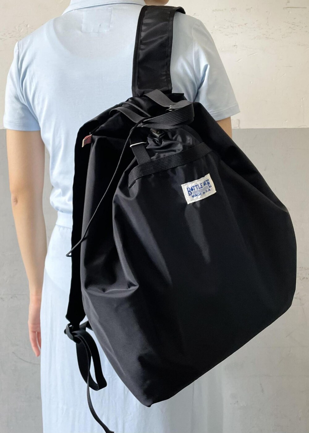 「BATTLE LAKE、バトルレイク、agnes b. pour ADAM ET ROPE'、agnes b.、アニエスベー、別注、ポロシャツ、ジップ、チャンキソール、シャワーサンダル、ブラック、リュック、ブルー、ロング、半袖」｜「BATTLE LAKEの【BATTLE LAKE】STOWAWAY PACK（バックパック/リュック、ブラック系）」を使った、OEさん（レディース・164cm）の春コーディネートの8枚目の写真