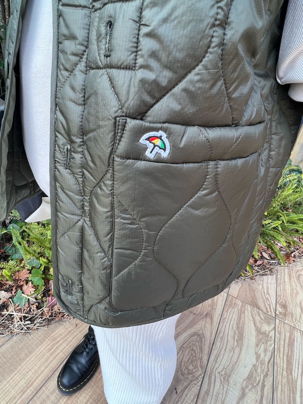 ホワイト系のバックパック/リュック、ホワイト系のパーカー、グリーン系のモッズコートを着用したレディースの冬コーディネートの3枚目の写真