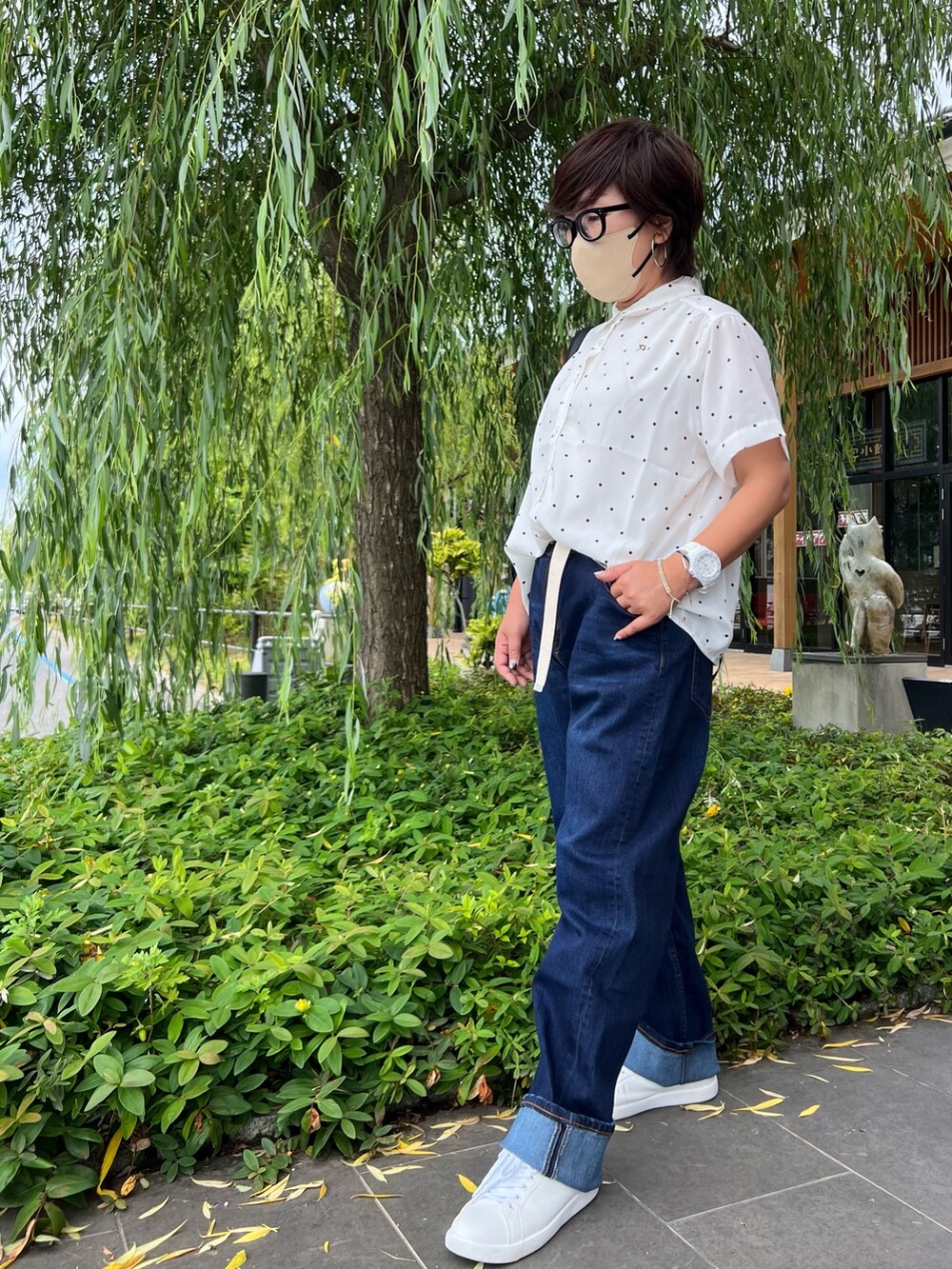 ブラック系のバックパック/リュック、ブルー系のデニムパンツ、ホワイト系のスニーカーを着用したレディースの春コーディネートの2枚目の写真