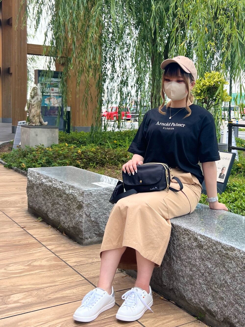 ブラック系のTシャツ/カットソー、ベージュ系のスカート、ブラック系のショルダーバッグを着用したレディースの夏コーディネートの2枚目の写真