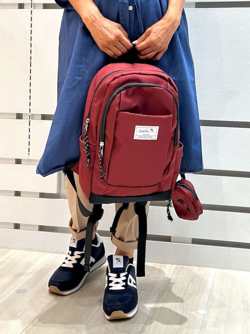 ブルー系のシャツワンピース、レッド系のバックパック/リュックを着用したレディースの秋コーディネートの3枚目の写真