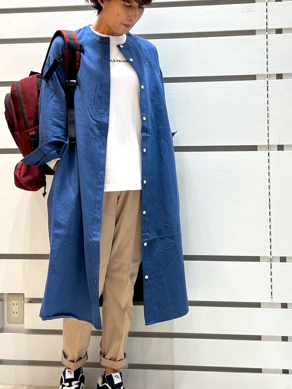 ブルー系のシャツワンピース、レッド系のバックパック/リュックを着用したレディースの秋コーディネートの2枚目の写真