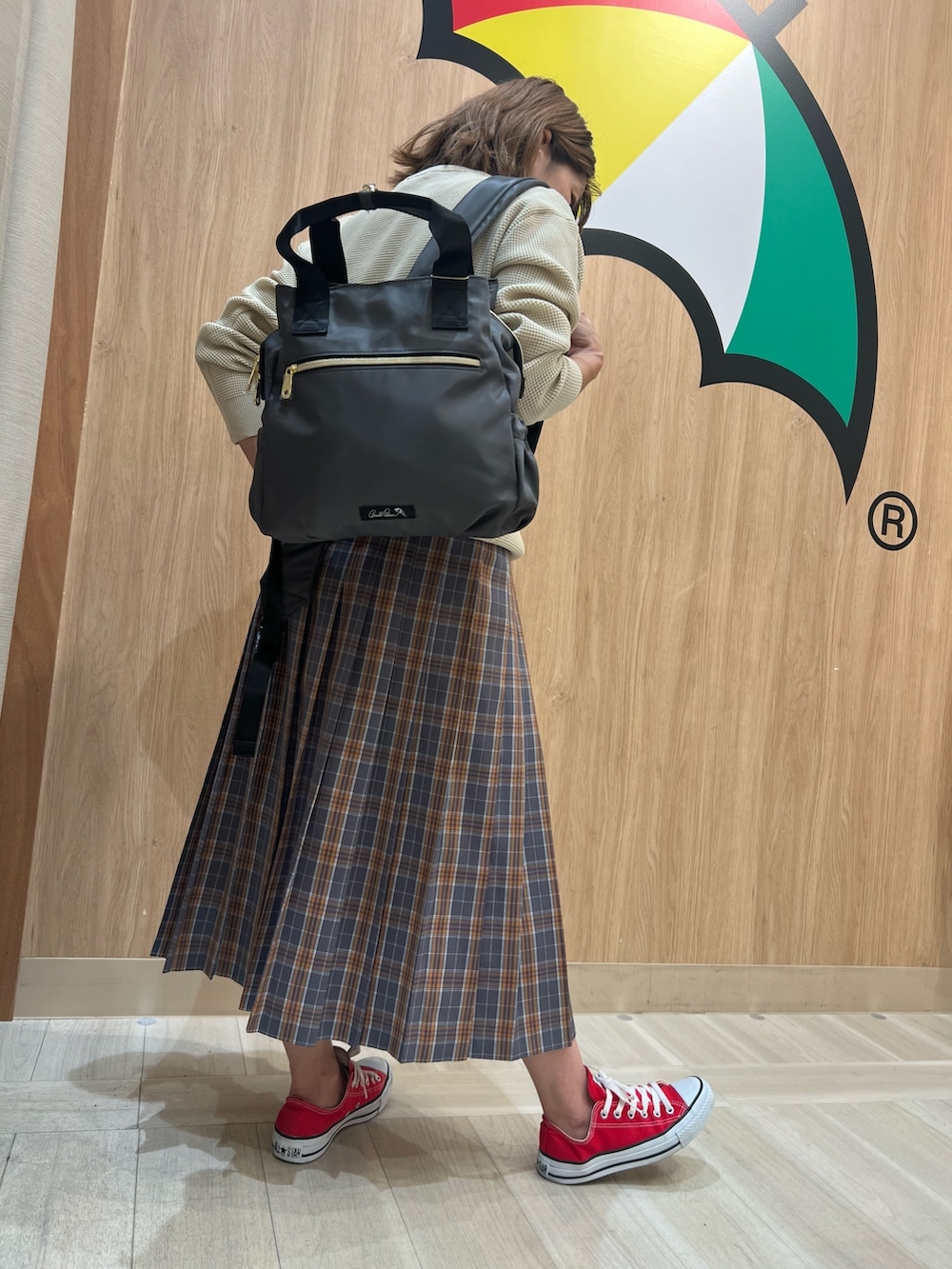 ホワイト系のニット/セーター、グレー系のスカート、グレー系のバックパック/リュックを着用したレディースの秋コーディネートの3枚目の写真