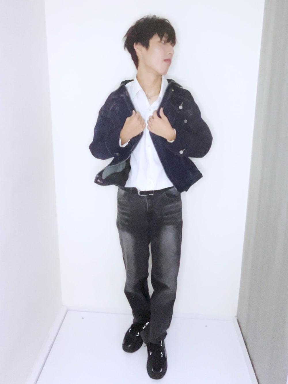 ブルー系のデニムジャケット、ホワイト系のテーラードジャケット、ブラック系のスニーカーを着用したメンズの秋コーディネートの3枚目の写真