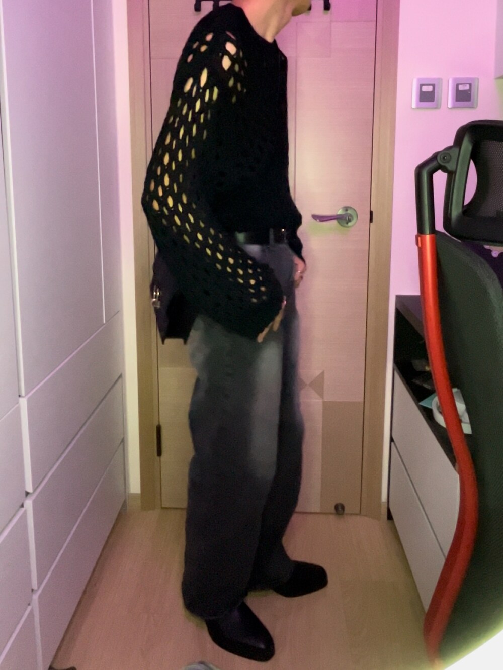 ブラック系のニット/セーター、ブラック系のブーツ、ブラック系のショルダーバッグを着用したメンズの春コーディネートの2枚目の写真