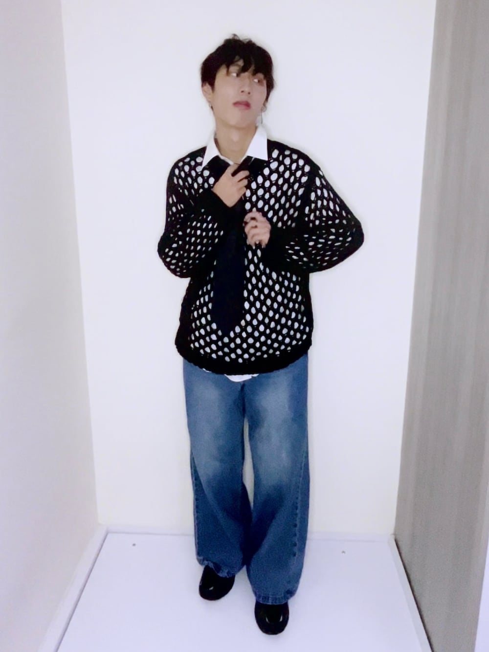 ブルー系のデニムパンツ、ブラック系のスニーカー、ブラック系のニット/セーターを着用したメンズの秋コーディネートの2枚目の写真