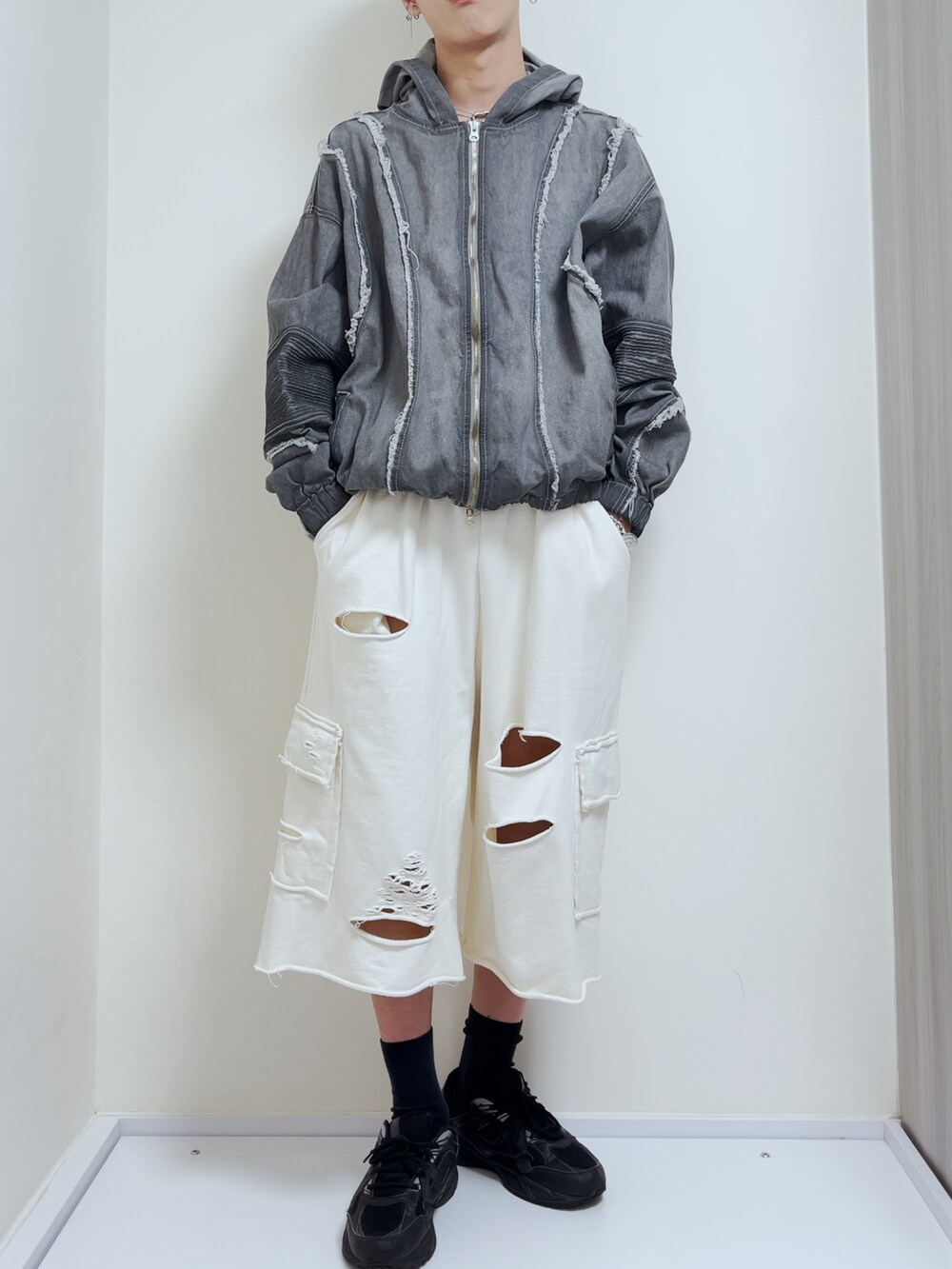 グレー系のブルゾン、ホワイト系のその他パンツ、ブラック系のスニーカーを着用したメンズの秋コーディネートの2枚目の写真