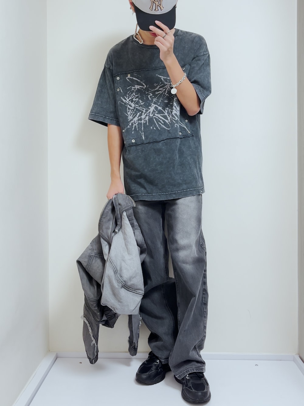 グレー系のブルゾン、ブラック系のTシャツ/カットソー、ブラック系のスニーカーを着用したメンズの秋コーディネートの3枚目の写真