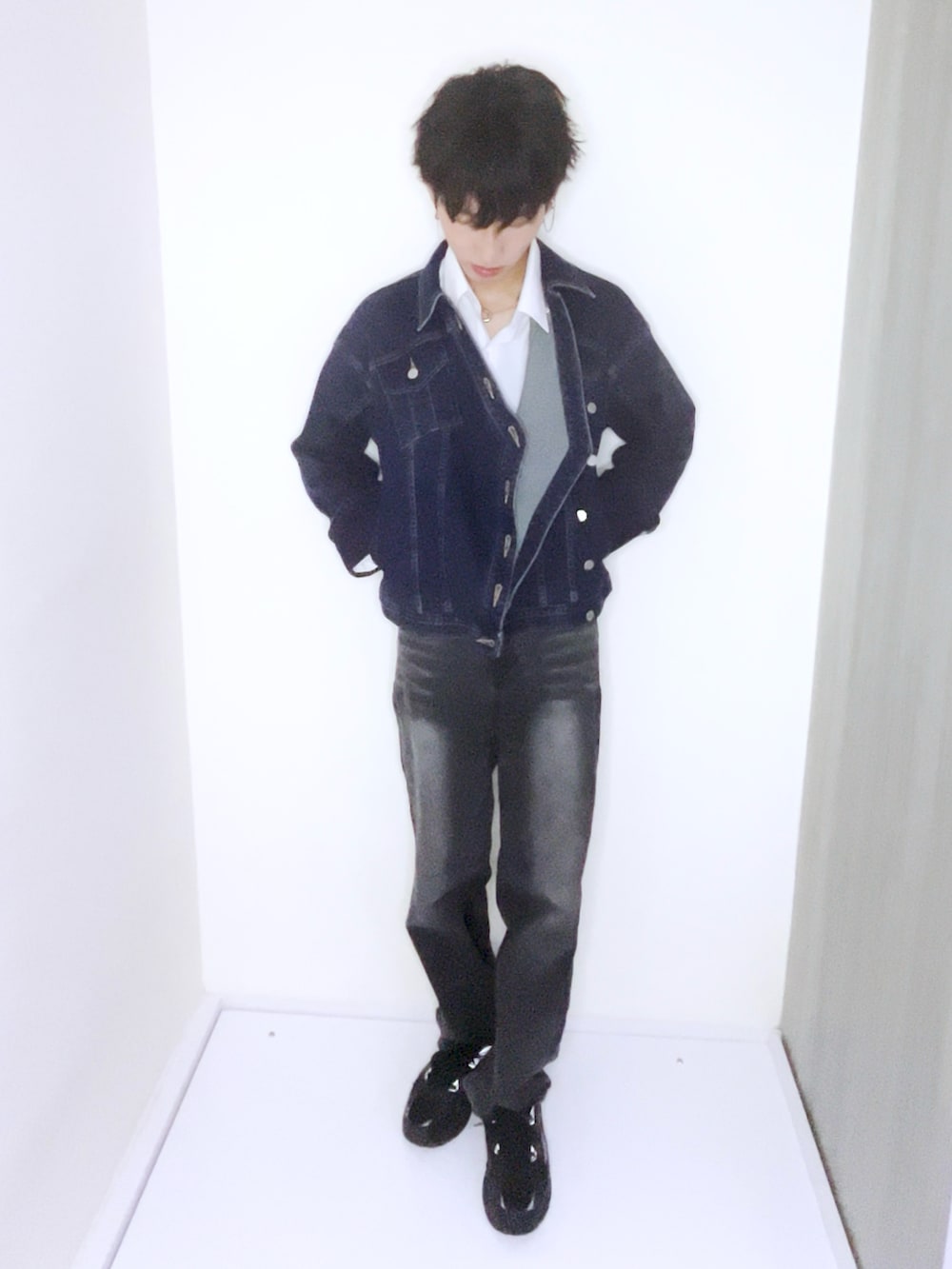 ブルー系のデニムジャケット、ホワイト系のテーラードジャケット、ブラック系のスニーカーを着用したメンズの秋コーディネートの2枚目の写真