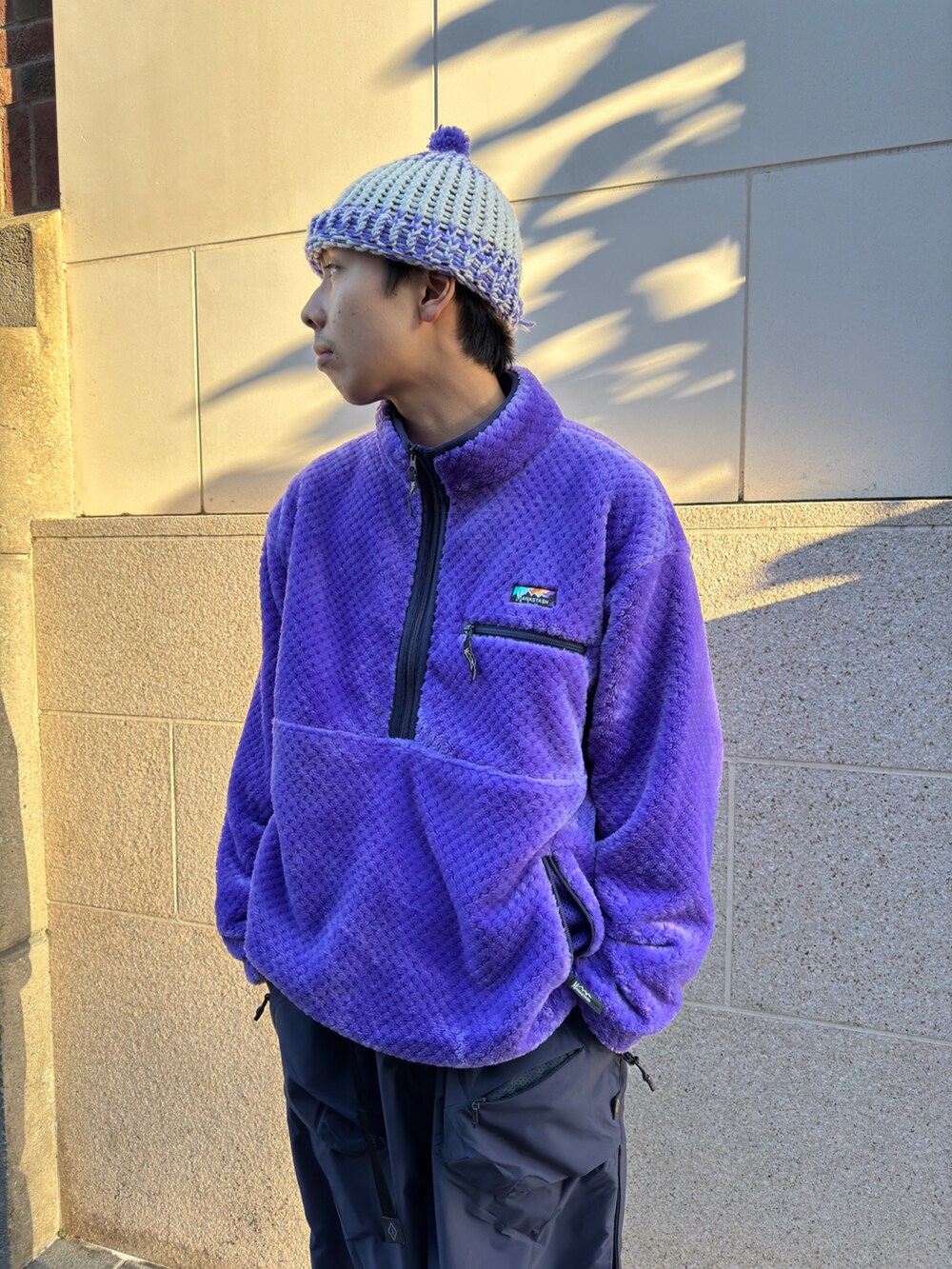 パープル系のブルゾン、ブラック系のその他パンツ、ブラック系のシューズを着用したメンズの冬コーディネートの3枚目の写真