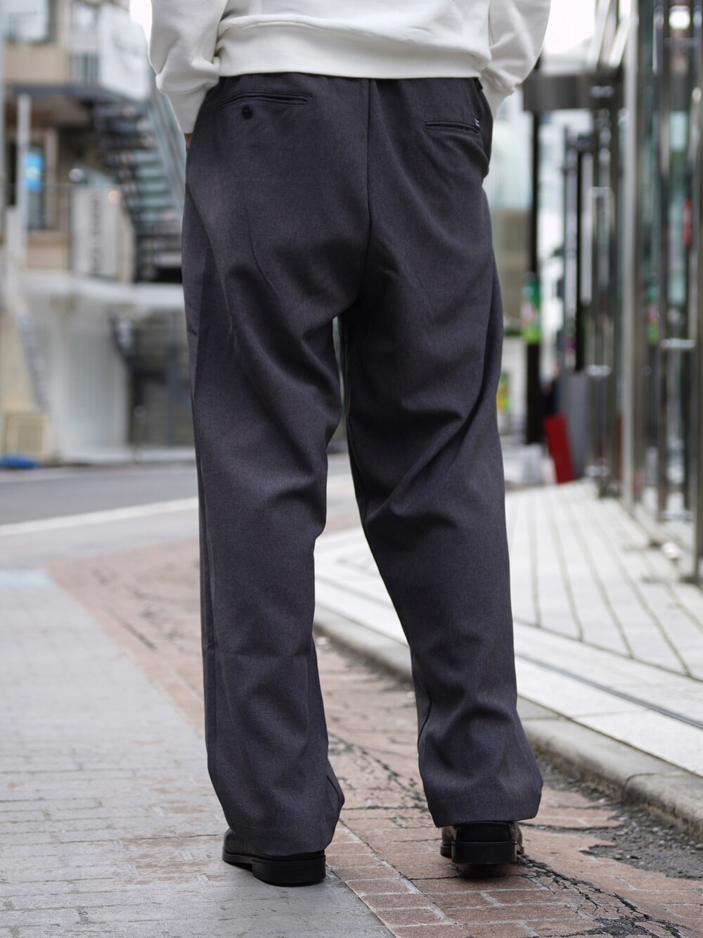 ホワイト系のスウェット、グレー系のスラックス、ブラック系のローファーを着用したメンズの秋コーディネートの9枚目の写真