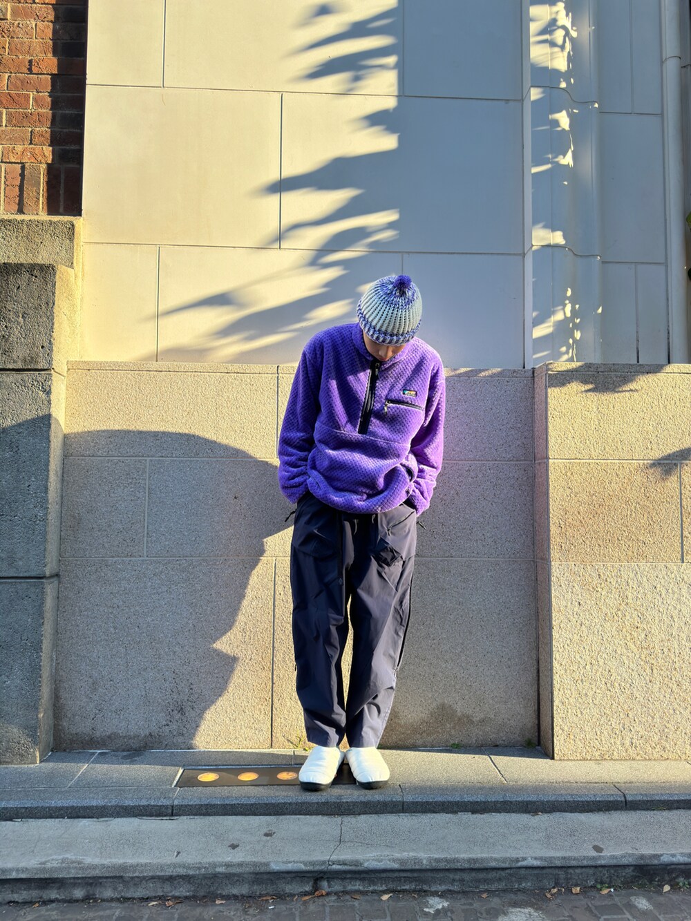 パープル系のブルゾン、ブラック系のその他パンツ、ブラック系のシューズを着用したメンズの冬コーディネートの2枚目の写真