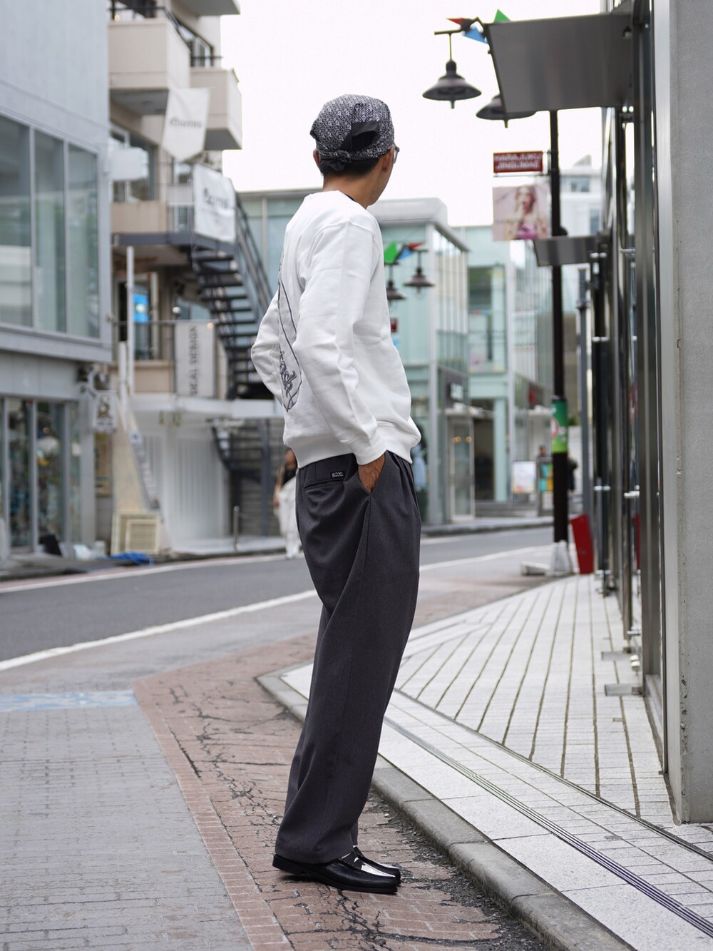 ホワイト系のスウェット、グレー系のスラックス、ブラック系のローファーを着用したメンズの秋コーディネートの2枚目の写真