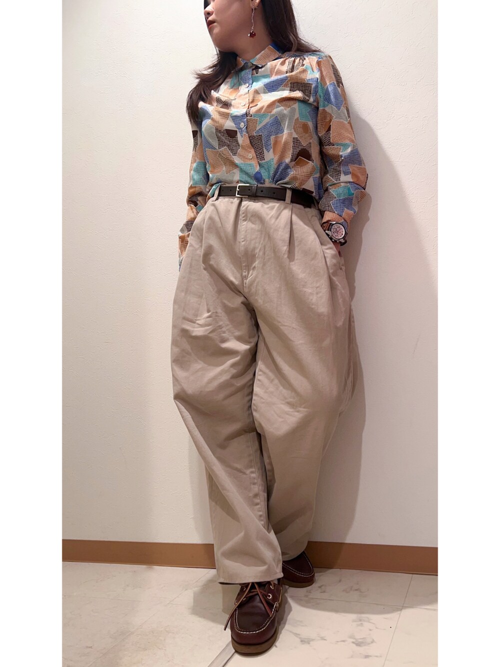 ブラウン系のシャツ/ブラウス、ベージュ系のチノパンツ、ブラウン系のモカシン/デッキシューズを着用したレディースの秋コーディネートの2枚目の写真