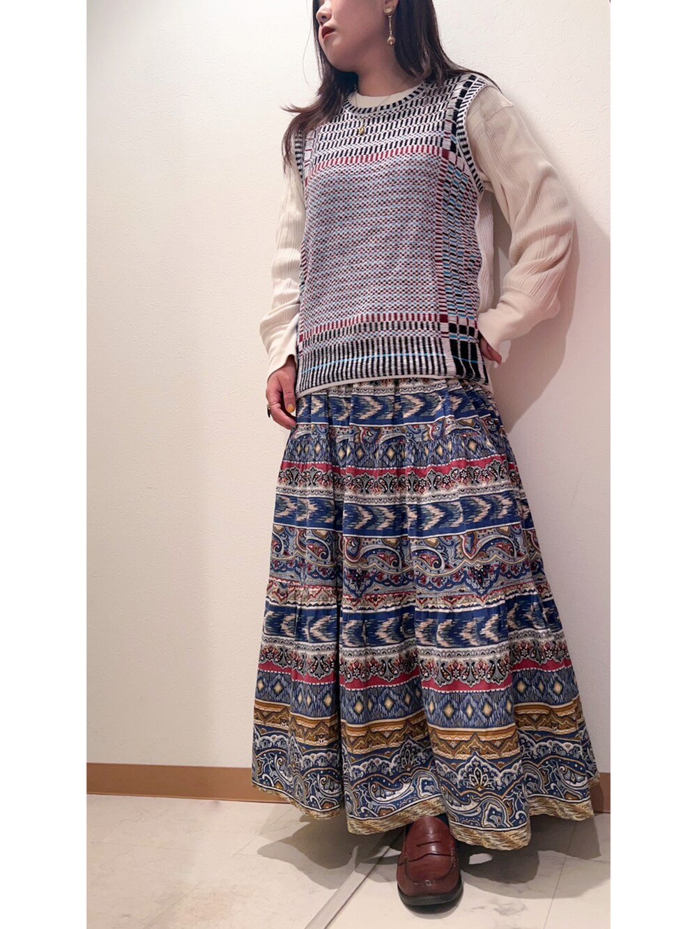 ブルー系のテーラードジャケット、ブルー系のスカート、ブラウン系のローファーを着用したレディースの秋コーディネートの2枚目の写真