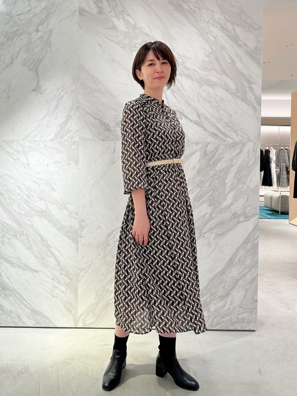 イエロー系のその他アウター、ブルー系のワンピース、ホワイト系のハンドバッグを着用したレディースの秋コーディネートの6枚目の写真