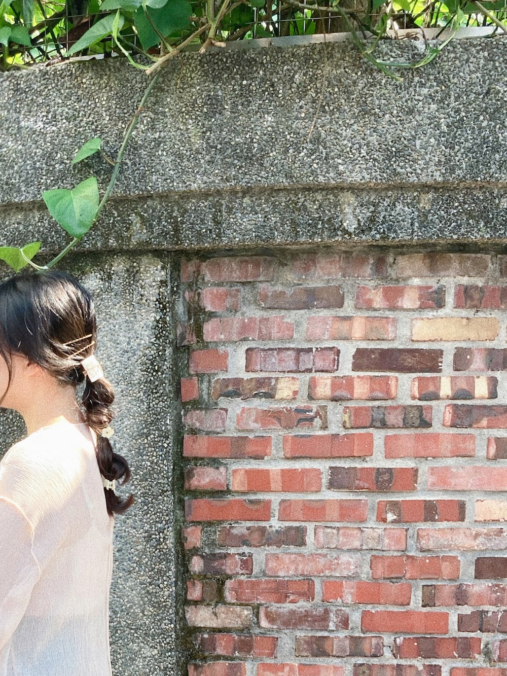 ブルー系のデニムパンツ、ベージュ系のトップス、ブラック系のスニーカーを着用したレディースの秋コーディネートの3枚目の写真