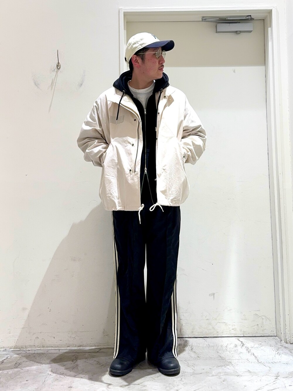 ホワイト系のTシャツ/カットソー、ブラック系のパーカー、ホワイト系のモッズコートを着用したメンズの春コーディネートの2枚目の写真