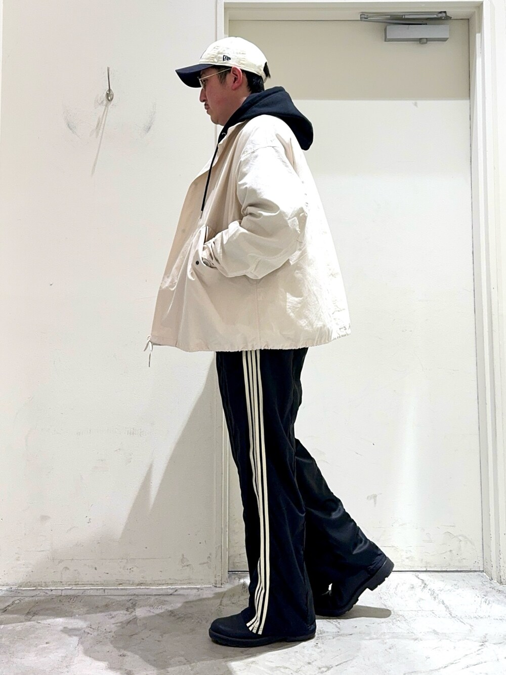 ホワイト系のTシャツ/カットソー、ブラック系のパーカー、ホワイト系のモッズコートを着用したメンズの春コーディネートの3枚目の写真