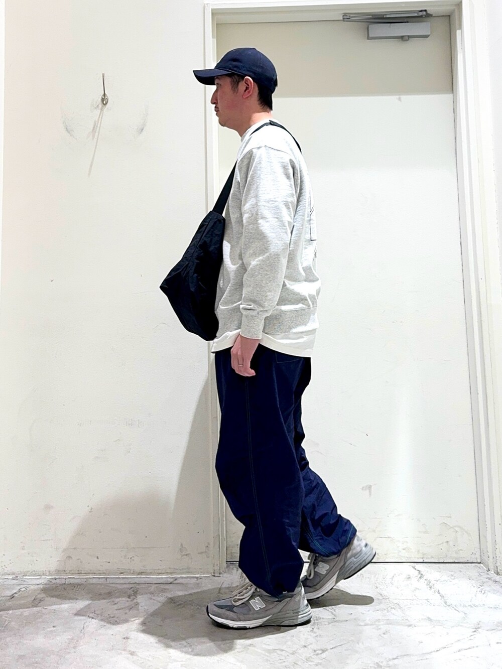 グレー系のスウェット、ブラック系のショルダーバッグ、ホワイト系のTシャツ/カットソーを着用したメンズの春コーディネートの2枚目の写真