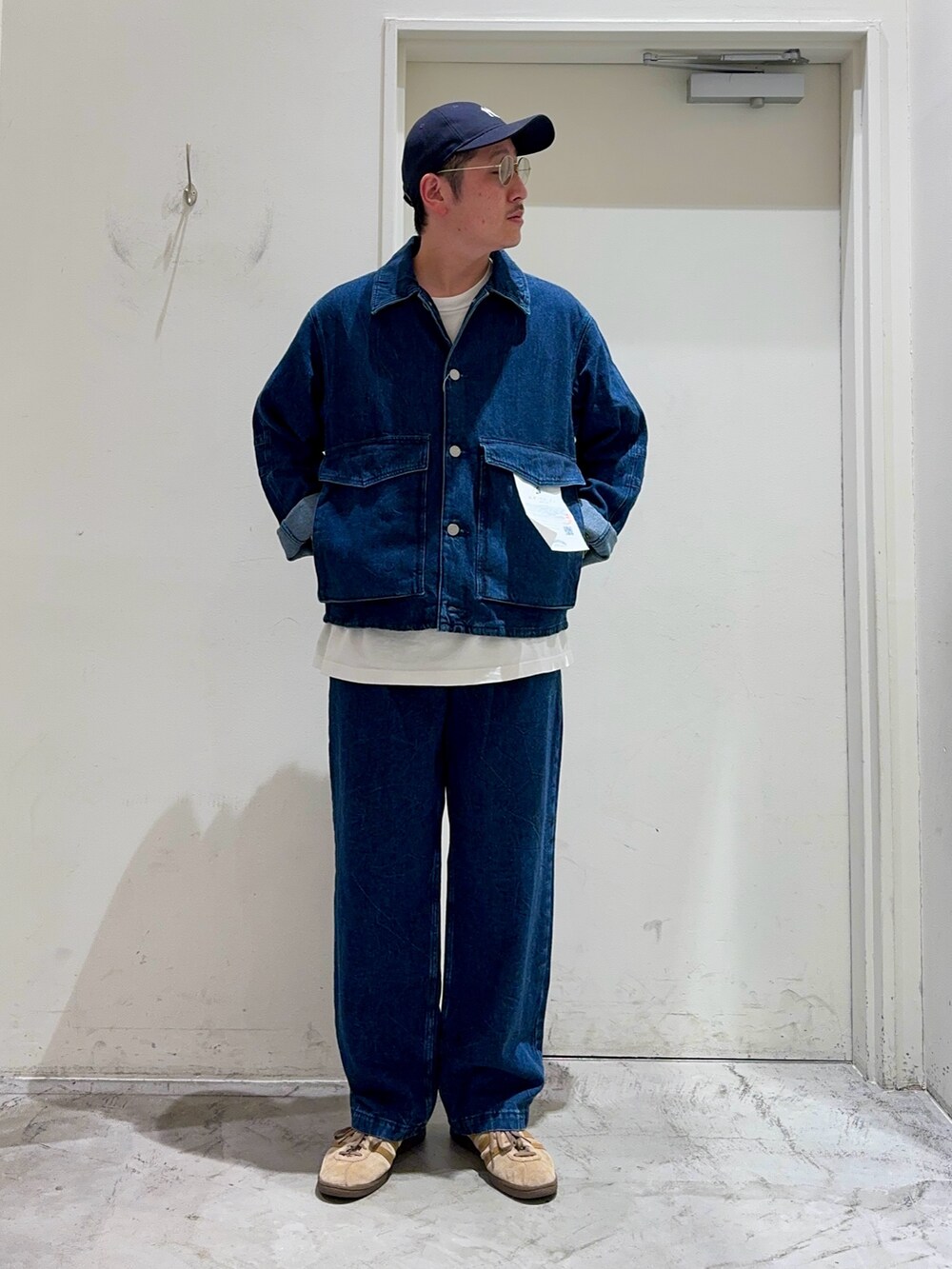 ブルー系のブルゾン、ホワイト系のTシャツ/カットソー、ブルー系のデニムパンツを着用したメンズの夏コーディネートの2枚目の写真